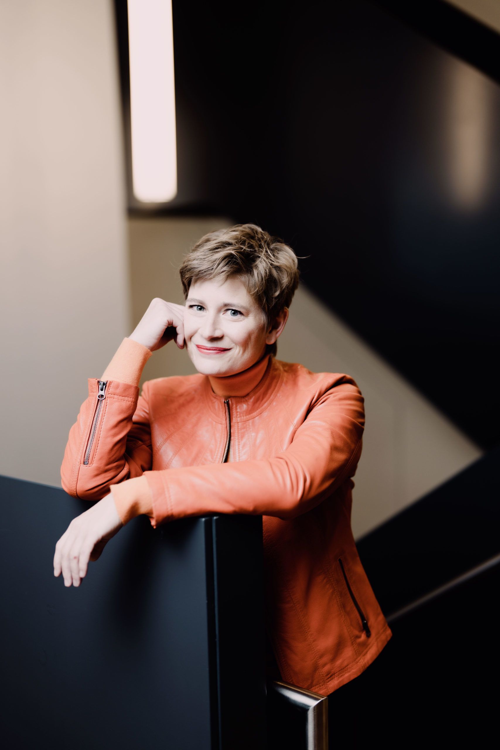 Portrait photograph of Anja Bihlmaier dressed in a orange leather jacket.