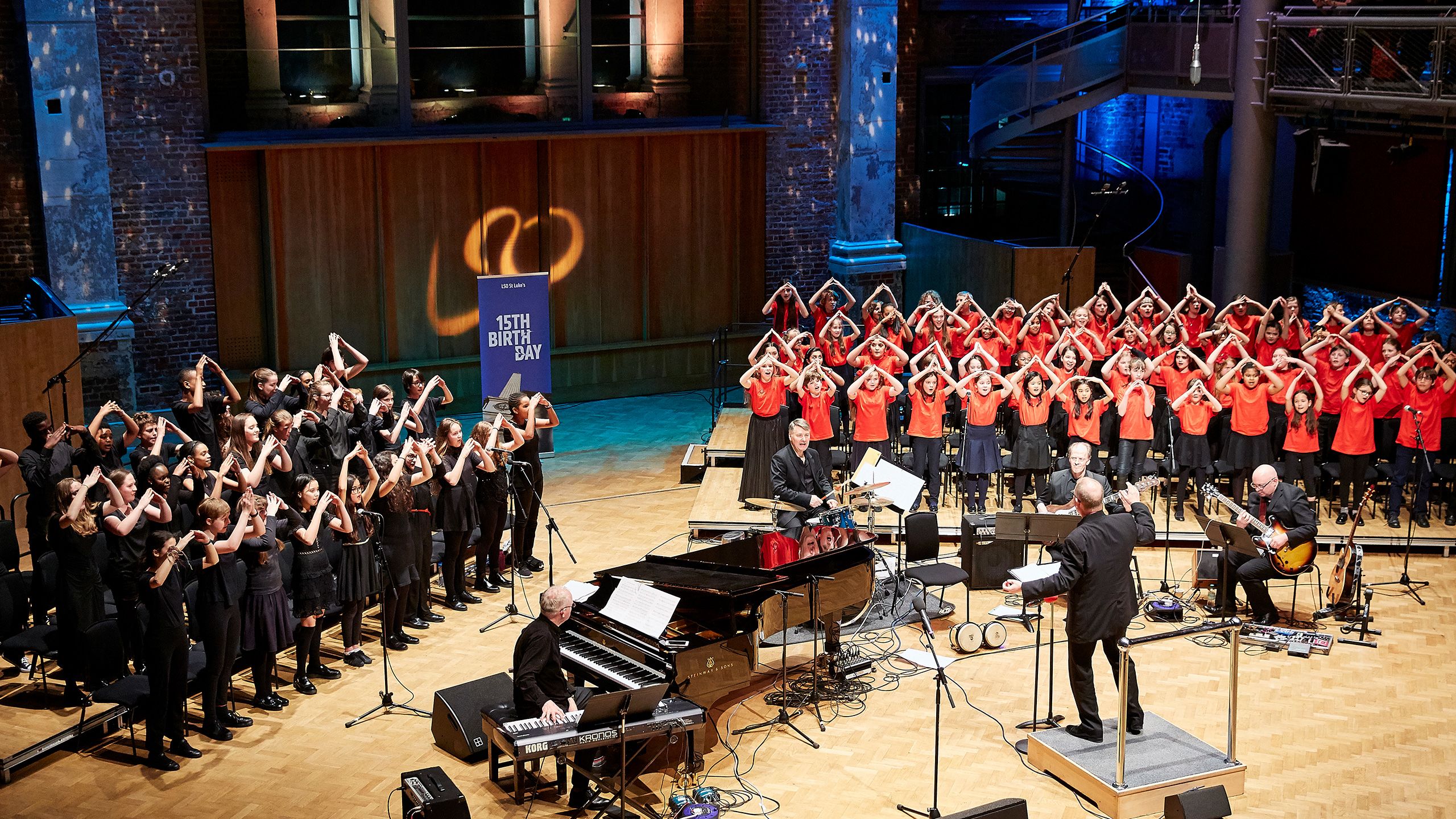Choirs on stage performing with a small band