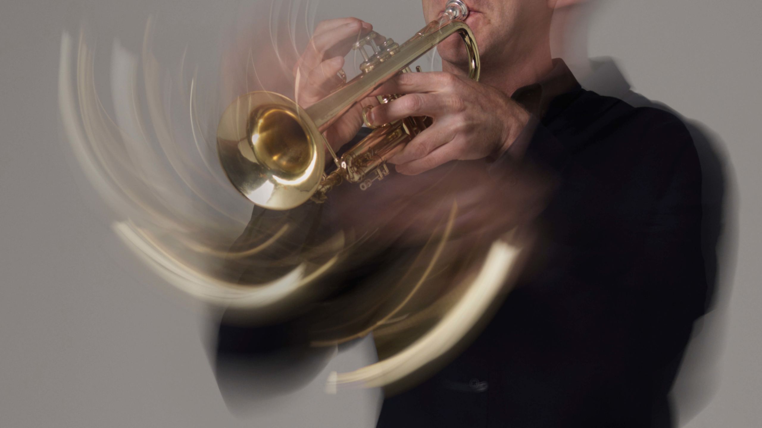 Close up photograph of a musician playing a trumpet.